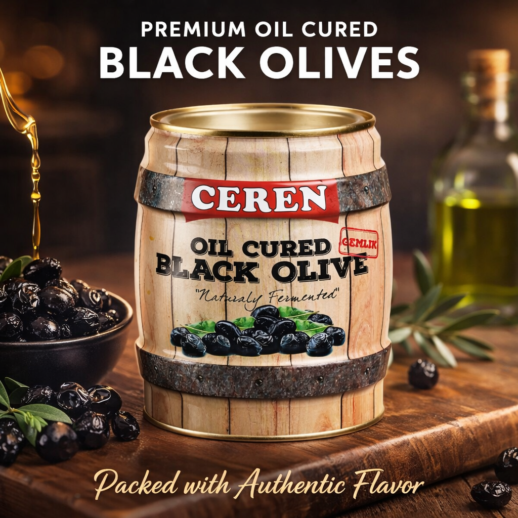 Cerén oil cured black olives in a wooden barrel with olive oil and olives on a wooden surface.